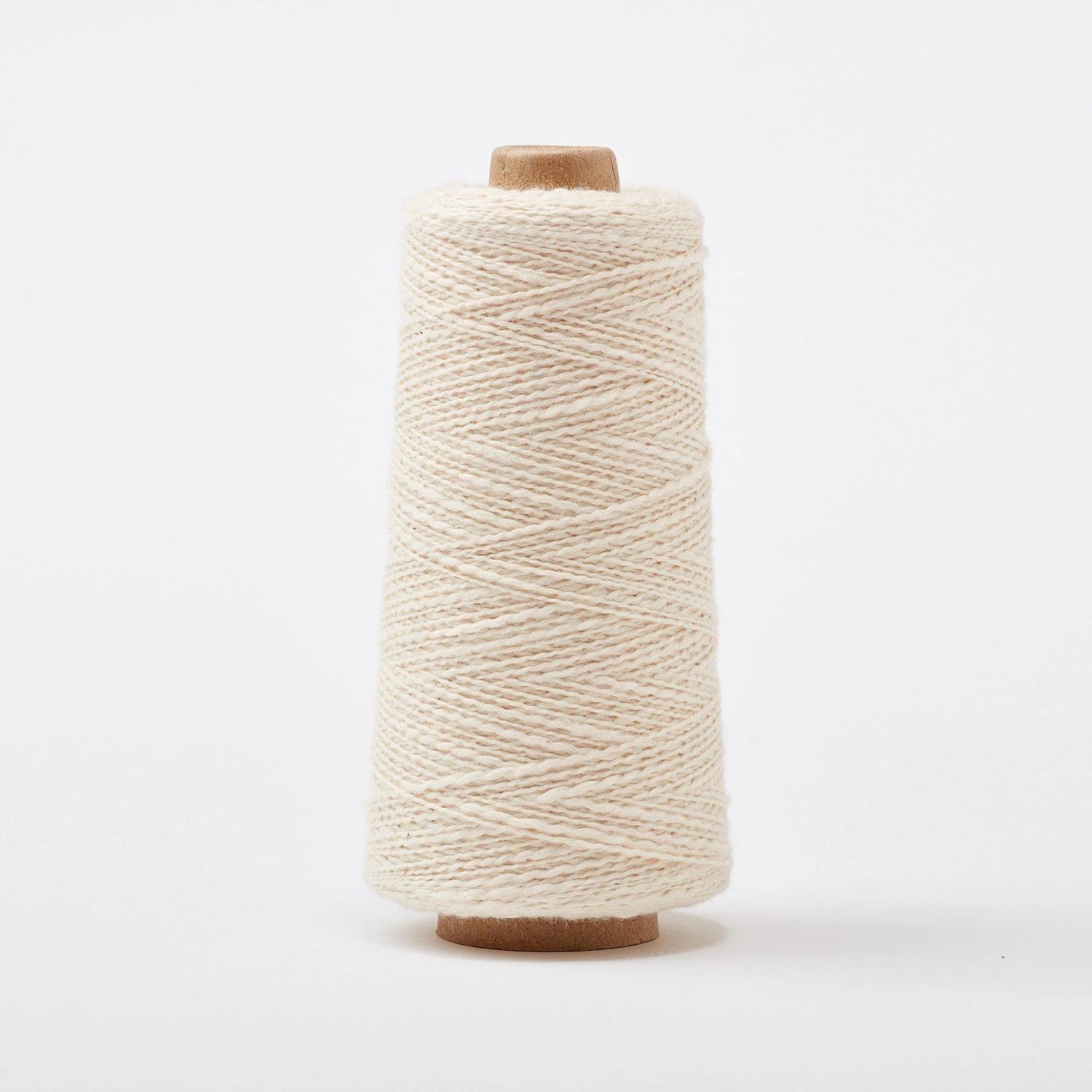 Spool of beige/white/nuetral yarn on a white background