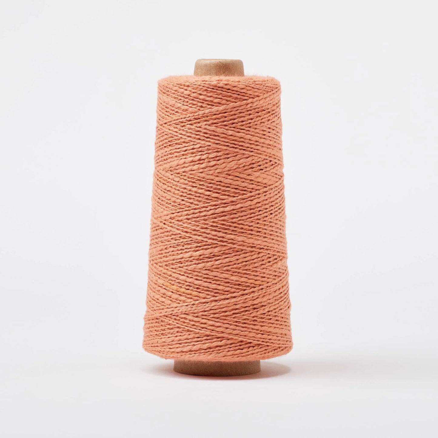 Spool of pink yarn on a white background